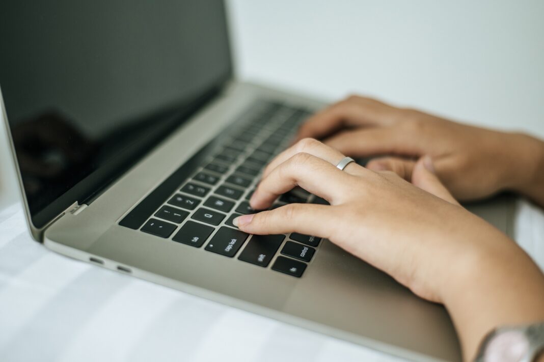 The hand that is put on the laptop.
